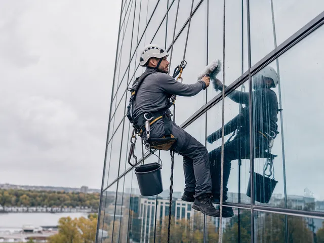 Höhenarbeit mit Seilzugang an einer Glasfassade als Symbol für Arbeitssicherheit in der Höhe
