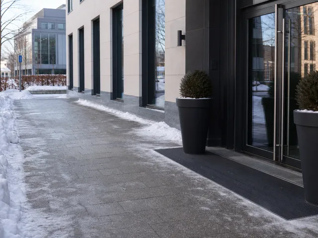 Freier winterlicher Gehweg vor einem Gebäude als Symbol für Verkehrssicherungspflicht