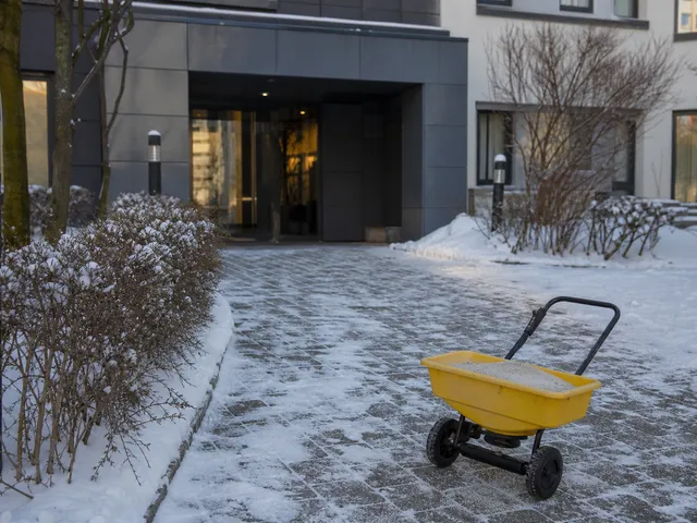 Verschneiter Gehweg vor einem Gebäudeeingang als Symbol für saisonale Pflichten wie Winterdienst