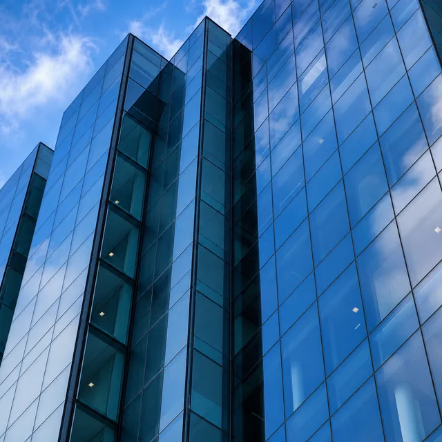 Moderne Glasfassade eines Hochhauses mit reflektierenden Scheiben